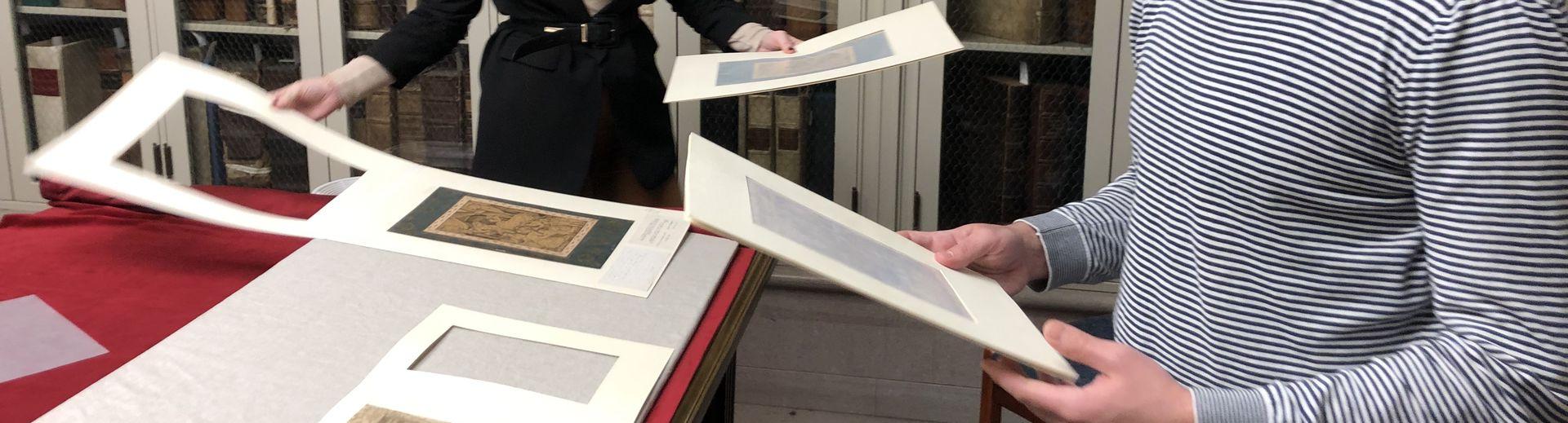 Two students look at images in a library.